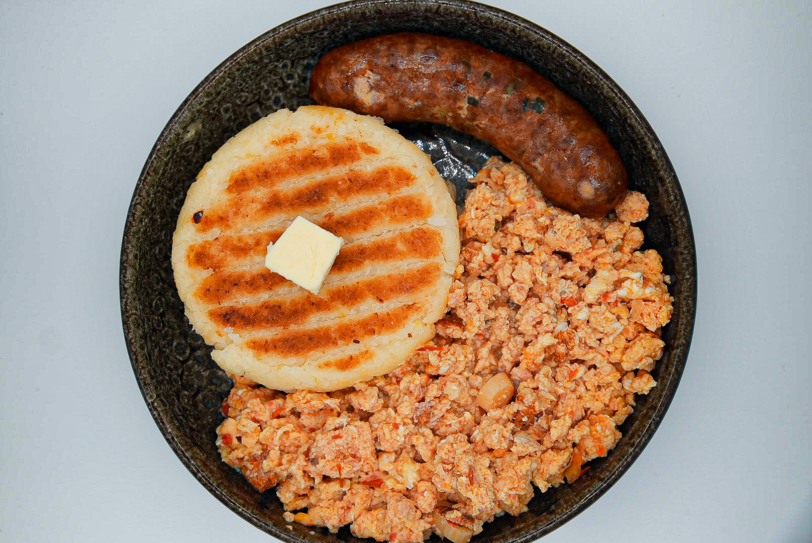 Arepa de queso, huevos revueltos, chorizo y café